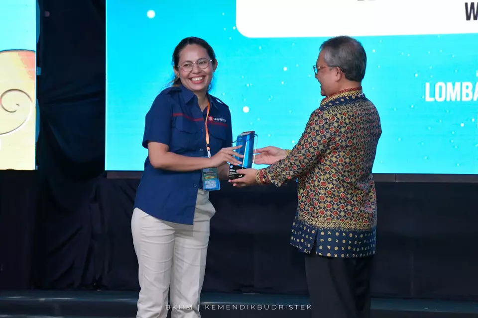 Jurnalis Beritasatu.com Maria Fatima Bona (kiri) menerima penghargaan sebagai pemenang pertama lomba karya jurnalistik kategori features wartawan dalam 