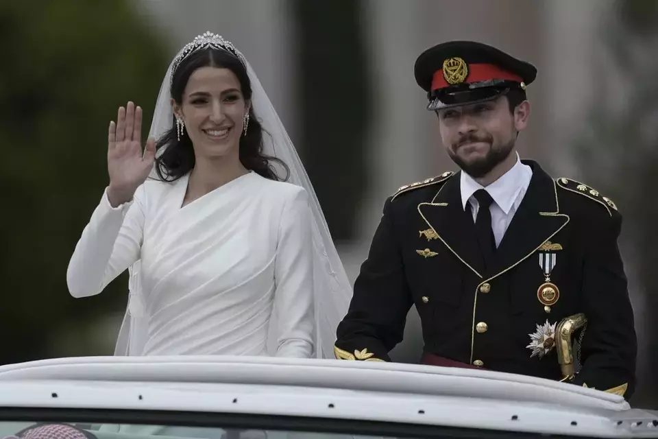 Putra Mahkota Yordania Hussein dan pasangannya dari Saudi Rajwa Alseif melambaikan tangan setelah upacara pernikahan mereka di Amman, Yordania, Kamis, 1 Juni 2023.