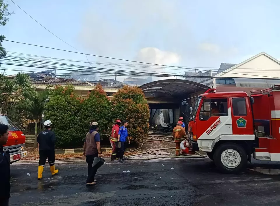Petugas pemadam kebakaran melakukan pembasahan gudang springbed yang terbakar di Jalan Raya Tidar terbakar, Kamis 8 Juni 2023.