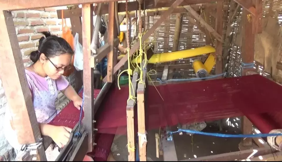Perajin tengah menenun sarung goyor di Desa Plumbongambang, Kecamatan Gudo, Kabupaten Jombang.