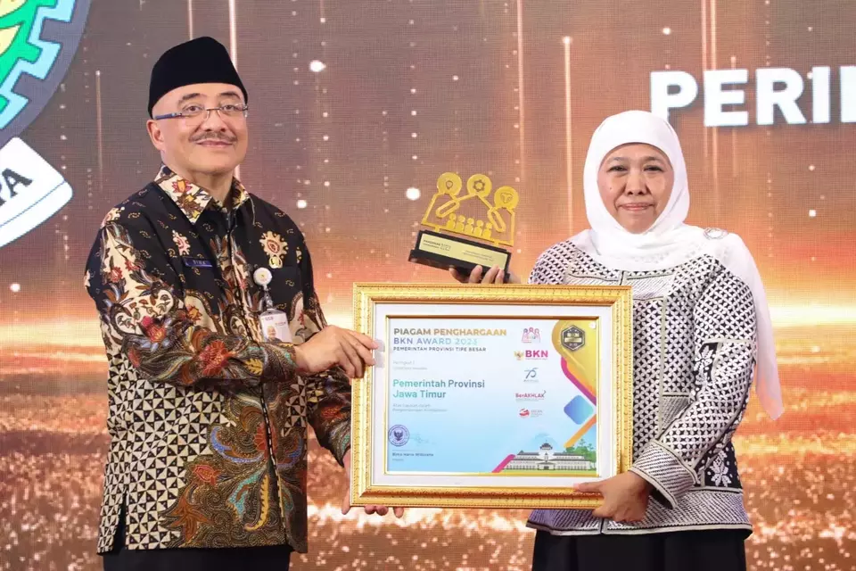 Gubernur Jawa Timur, Khofifah Indar Parawansa (kanan) menerima penghargaan BKN Award dari Plt Kepala BKN Bima Haria Wibisana.