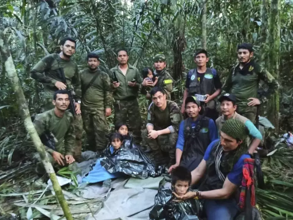 Tentara Kolombia berfoto bersama empat anak yang hilang setelah kecelakaan pesawat mematikan, di hutan Solano, negara bagian Caqueta, Kolombia.