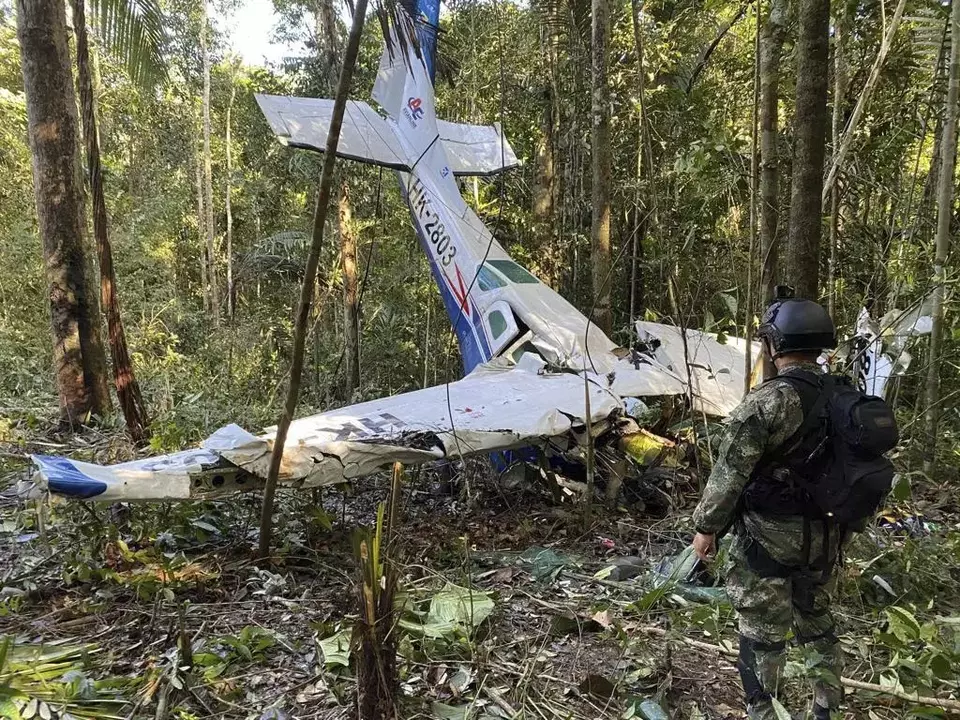 Foto pada 18 Mei 2023 menunjukkan tentara Kolombia berdiri di depan reruntuhan pesawat Cessna C206 yang jatuh di hutan Solano di negara bagian Caqueta.