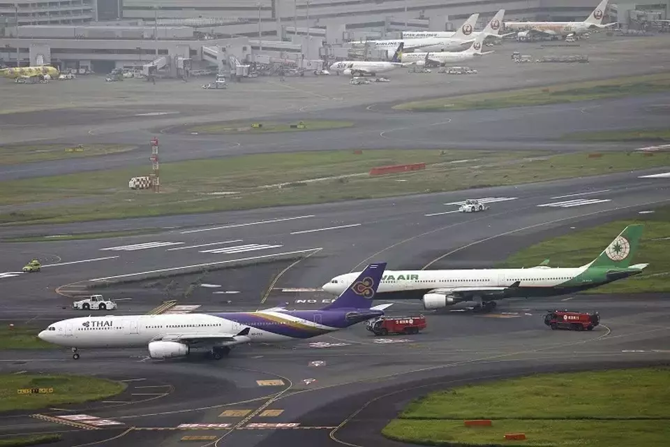 Pesawat Thai Airways (kiri), dan Eva Airways berdekatan di landasan pacu, setelah kedua pesawat penumpang tersebut secara tidak sengaja saling bersenggolan di bandara Haneda di Tokyo, Sabtu, 10 Juni 2023.