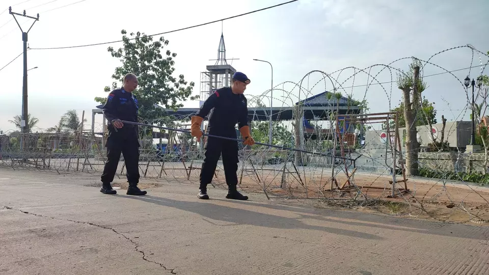 Petugas kepolisian dari Batalyon C Brimob Polda Jabar, memasang kawat berduri di halaman gerbang masuk Ponpes Al Zaytun, Kamis, 22 Juni 2023.