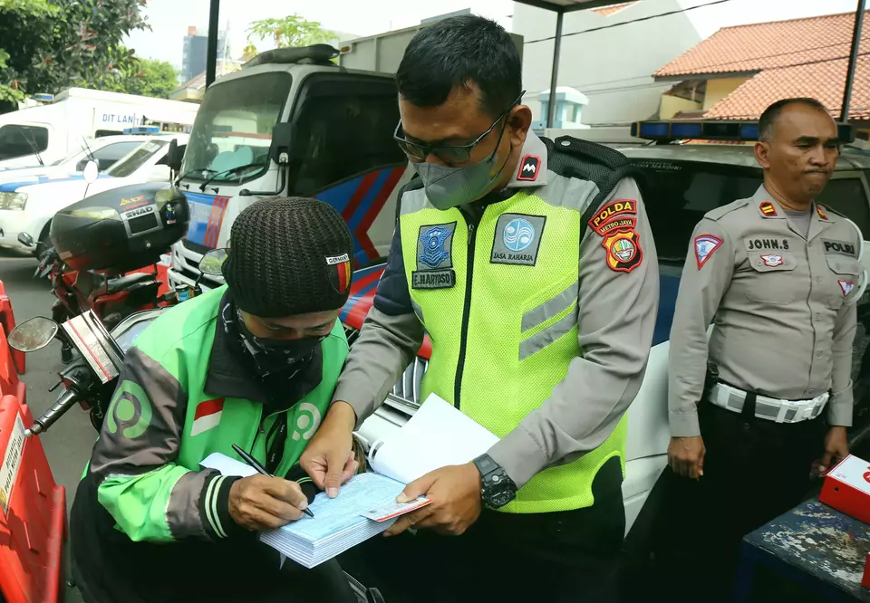 Petugas memberikan tilang kepada pengendara yang kendaraannya tak lolos uji emisi di Subdit Gakkum Ditlantas Polda Metro Jaya, Jakarta, Jumat 1 September 2023. Direktorat Lalu Lintas Polda Metro Jaya bersama Dinas Lingkungan Hidup DKI Jakarta mulai memberlakukan tilang uji emisi pada kendaraan roda dua dan roda empat sebagai upaya mendorong masyarakat berkontribusi dalam mengatasi masalah buruknya kualitas udara di Ibu Kota dan menerapkan denda sanksi tilang bagi kendaraan tak lolos uji emisi sebesar Rp250.000 bagi motor dan Rp500.000 untuk mobil.