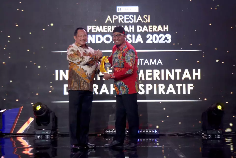 Menteri Dalam Negeri Tito Karnavian, menyerahkan penghargaan Apresiasi Pemerintah Daerah Indonesia 2023, kategori Utama Inisiatif Pemerintah Daerah Inspiratif kepada Bupati Sumenep Achmad Fauzi (kanan), di Jakarta, Selasa, 12 September 2023.