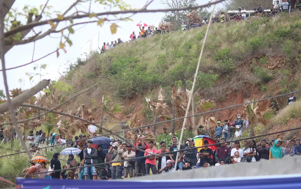 Ratusan menonton Pertamina Grand Prix of Indonesia 2023 atau MotoGP Mandalika 2023 di atas bukit di sekitar Sirkuit Internasional Pertamina Mandalika, Lombok, Nusa Tenggara Barat, Minggu, 15 Oktober 2023. 