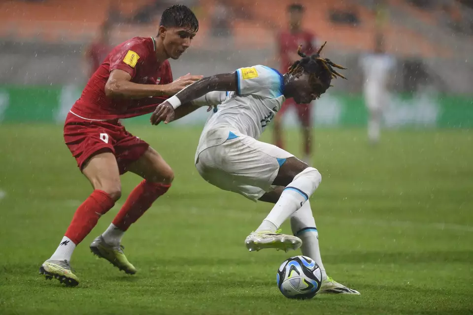 Penyerang Inggris Joel Ndala (kanan) berebut bola dengan pemain Iran Yaghoob Barajeh (kiri) saat bertanding dalam laga penyisihan grup C Piala Dunia U-17 di Jakarta International Stadium, Jakarta, Selasa, 14 November 2023. 