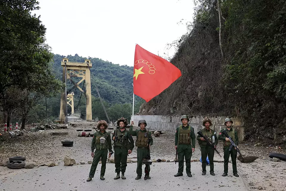 Tentara Aliansi Demokratik Nasional Myanmar berfoto di depan jembatan Kunlong di kotapraja Kunlong di negara bagian Shan, Myanmar, Minggu, 12 November 2023. 
