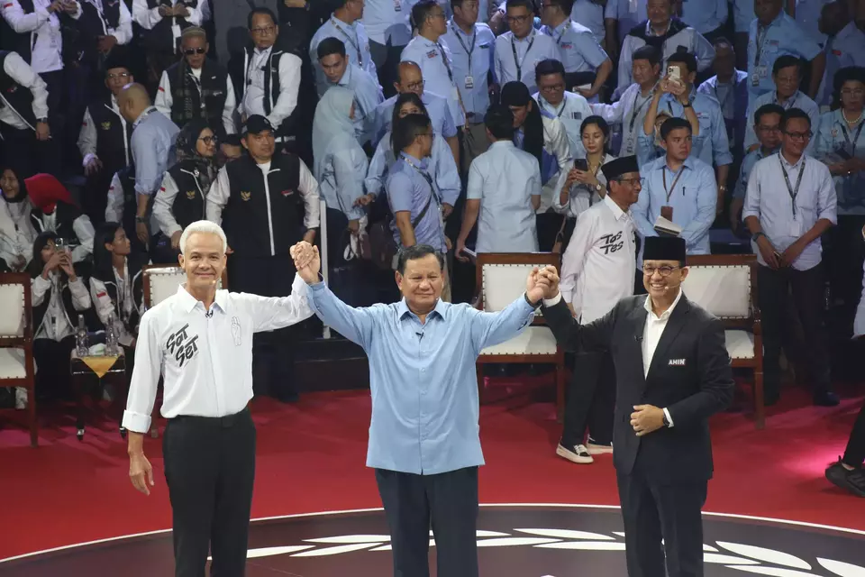 Kandidat presiden (dari kiri) Ganjar Pranowo, Prabowo Subianto, dan Anies Baswedan berpegangan tangan saat berpose di depan fotografer seusai debat perdana calon presiden 2024 di KPU, Jakarta, Selasa, 12 Desember 2023.