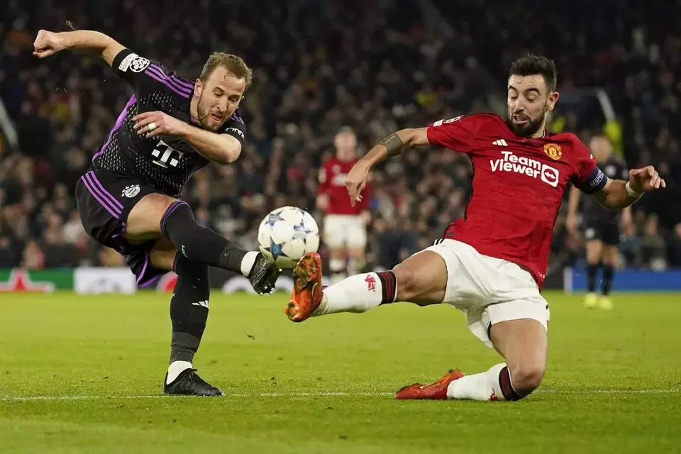 Gelandang Manchester United, Bruno Fernandes (kanan), mencoba menahan tendangan striker Bayern Munchen dalam partai Liga Champions grup A, Selasa, 12 Desember 2023, di Stadion Old Trafford.