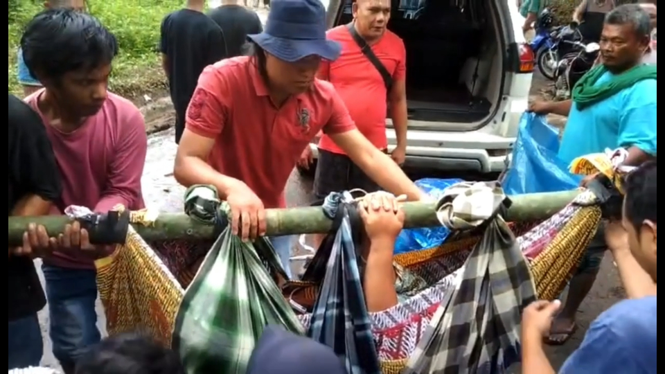 Puluhan warga Kabupaten Mandailing Natal, Sumatera Utara bergotong royong untuk menandu seorang ibu hamil menuju rumah sakit yang akan melahirkan.