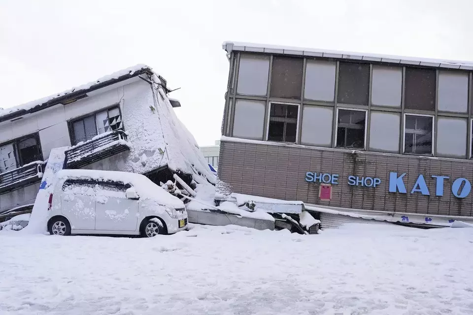 Bangunan yang ambruk akibat gempa kini tertutup salju di Anamizu, Prefektur Ishikawa, Jepang pada Senin, 8 Januari 2024. 