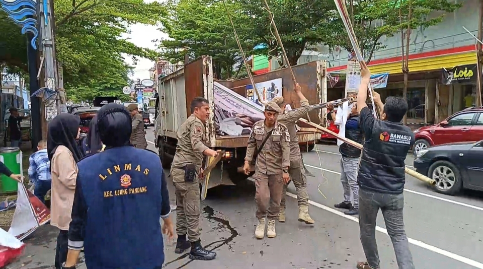 Petugas tengah membersihkan alat peraga kampanye (APK) di kawasan Pelabuhan Makassar, Sulawesi Selatan, Minggu, 11 Februari 2024.