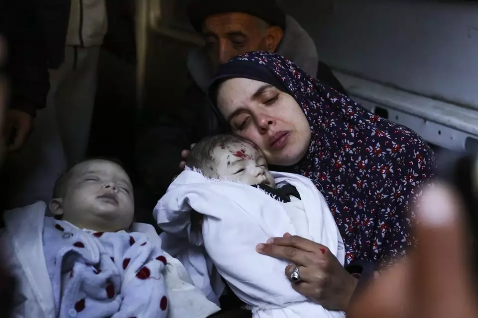 Rania Abu Anza menggendong anak kembarnya yang tewas akibat bom Israel di Kota Rafah, di Jalur Gaza selatan, Minggu 3 Maret 2024.