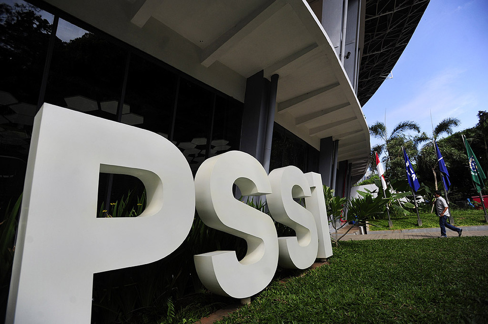 Seorang karyawan melintasi tulisan PSSI di Kantor PSSI Senayan, Jakarta.