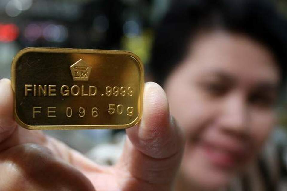 Penjual emas menunjukan Logam Mulia 50 gram di salah satu pusat perbelanjaan di Jakarta (19/8). Harga emas batangan di dalam negeri kembali melonjak, Divisi Logam Mulia PT Aneka Tambang Tbk (Antam) menjual harga emas batangan dengan harga tertinggi hingga Rp 552.000 per gram. Sementara itu Lampung Barat menawarkan investasi tambang emas di wilayahnya