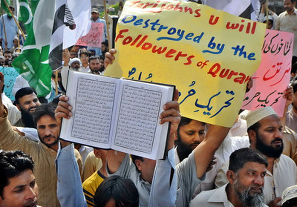 Pengunjuk rasa di Pakistan memegang Al Quran dan spanduk, memprotes pembakaran kitab suci itu oleh tentara Amerika Serikat. Aksi unjuk rasa berlangsung pada bulan Februari 2012