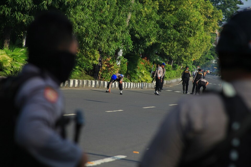 Polisi menyisir jalan untuk mencari serpihan bom saat proses identifikasi terhadap pelaku bom bunuh diri di Mapolresta solo, Jawa Tengah, Selasa 5 Juli 2016.