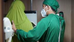 Petugas kesehatan sedang memeriksa kondisi paru pasien