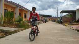 Seorang anak sedang naik sepeda melintas di perumahan subsidi yang dicananngkan pemerintah. (foto: Istimewa)