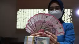 Petugas menunjukkan uang dolar Amerika Serikat (AS) dan uang rupiah di salah satu kantor cabang PT. Bank Mandiri Persero Tbk di Jakarta pada 31 Januari 2023. (Foto: ANTARA FOTO/Reno Esnir/tom)