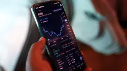 Investor melihat pergerakan indeks harga saham gabungan (IHSG) melalui layer telepon genggam. (B-Universe Photo/Mohammad Defrizal)