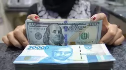 Pekerja menunjukkan uang dolar AS dan rupiah di salah satu gerai penukaran mata uang di Jakarta pada 5 Januari 2022. (Foto: ANTARA FOTO/Dhemas Reviyanto/wsj)
