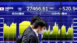 Orang yang lewat melewati monitor listrik yang menampilkan rata-rata saham Nikkei Jepang dan pergerakan terkini di luar bank di Tokyo, Jepang pada 22 Maret 2023. (Foto: Reuters/Issei Kato)