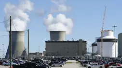 Reaktor untuk Unit 3 dan 4 berada di pembangkit listrik tenaga nuklir (PLTN) Plant Vogtle Georgia Power pada 20 Januari 2023 di Waynesboro, Amerika Serikat (AS) dengan menara pendingin Unit 1 dan 2 yang lebih tua mengepulkan uap di latar belakang pada 24 Mei 2023. (Foto: AP Photo/John Bazemore)