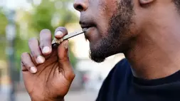 Seorang pria menggunakan alat penguap (vaporizer) Juul di Atlanta, Georgia, Amerika Serikat pada 26 September 2019. (Foto: Elijah Nouvelage / Reuters)