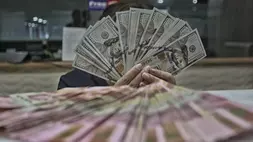 Petugas menghitung uang pecahan rupiah dan dolar AS di gerai penukaran mata uang asing di Jakarta. (B-Universe Photo/Joanito De Saojoao)