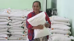 Warga penerima manfaat membawa beras dalam karung saat pengambilan bantuan pangan cadangan beras di Balai Kelurahan Bangsal, Kediri, Jawa Timur. (ANTARA FOTO/Prasetia Fauzani/nym)