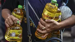 Seorang warga membeli minyak goreng di pasar pangan rakyat murah di Pura Agung Giri Natha, Semarang. (ANTARA FOTO/Aprillio Akbar)