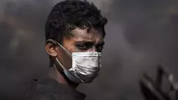 Mohammed Najm beristirahat sejenak saat bekerja di pembakar darurat yang digunakan untuk mengekstrak bahan bakar dari plastik cair untuk dijual di sepanjang Jalan Laut, sebelah selatan Kota Gaza, Minggu (22/6/2025). (Foto: AP/ Abdel Kareem Hana)