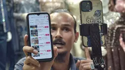 Pedagang menggunakan gawai memasarkan stok yang barang yang dijual secara daring di Pasar Tanah Abang, Jakarta Pusat. (ANTARA FOTO/ Fakhri Hermansyah)