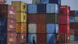 Seorang pekerja berjalan di dekat kontainer pengiriman di Terminal Peti Kemas IPC di Pelabuhan Tanjung Priok di Jakarta. (Foto: AP/ Achmad Ibrahim)