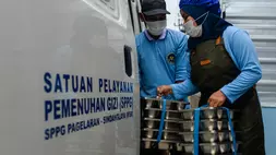 Petugas memasukkan makan bergizi gratis (MBG) ke dalam mobil untuk didistribusikan ke sekolah di SPPG Sindanglaya, Pandeglang, Banten, baru-baru ini. (ANTARA FOTO/Muhammad Bagus Khoirunas)