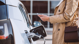 Ilustrasi Seorang pemilik kendaraan sedang mengisi daya mobil di stasiun pengisian kendaraan listrik. (Freepik)