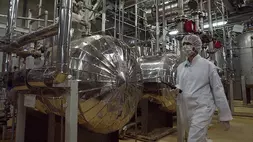 Seorang petugas keamanan Iran dengan pakaian pelindung berjalan melalui sebagian Fasilitas Konversi Uranium di luar kota Isfahan, Iran. (Foto: AP/ Vahid Salemi)