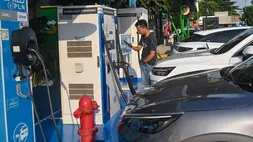 Seorang  pria memindai kode batang untuk mengisi daya mobil listrik di Stasiun Pengisian Kendaraan Listrik Umum (SPKLU) PLN di rest area KM 57 Tol Jakarta-Cikampek, Karawang, Jawa Barat, belum lama ini. (ANTARA FOTO/Fakhri Hermansyah)