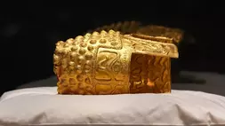 Barang-barang emas Dacia, sebuah helm berusia 2.500 tahun dan gelang tangan, yang dicuri dari sebuah museum di Belanda dan kemudian ditemukan kembali oleh pihak berwenang Belanda, dipresentasikan selama konferensi pers setelah dikembalikan, di Museum Sejarah Nasional Rumania, di Bukares, Rumania, Selasa (21/4/2026). (Foto: AP/ Andreea Alexandru)