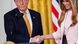 Presiden AS Donald Trump berjabat tangan dengan Ibu Negara Melania Trump saat acara untuk para ibu militer di Ruang Timur Gedung Putih, Rabu (6/5/2026) di Washington, AS. (Foto: AP/ Julia Demaree Nikhinson)