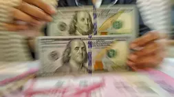 Petugas kasir menunjukkan uang pecahan dolar Amerika Serikat (AS) di gerai penukaran mata uang asing Ayu Masagung, Jakarta Pusat. (B-Universe Photo/Joanito De Saojoao)/