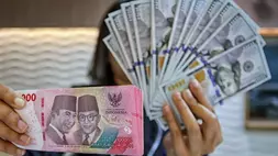 Petugas kasir menunjukkan uang pecahan dolar Amerika Serikat (AS) di gerai penukaran mata uang asing Ayu Masagung, Jakarta Pusat, Selasa (12/5/2026). (B-Universe Photo/Joanito De Saojoao)