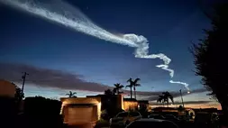 Jejak kondensasi dari roket SpaceX Falcon 9, yang diluncurkan dari Pangkalan Angkatan Luar Angkasa Vandenberg, terlihat di atas rumah-rumah di San Diego, AS. (Foto: AP/ Gregory Bull)