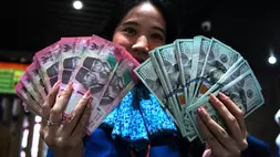 Karyawan menunjukkan uang pecahan rupiah dan dolar Amerika Serikat (AS) di gerai penukaran mata uang asing Haji La Tunrung, Makassar, Sulawesi Selatan, Rabu (20/5/2026). (ANTARA FOTO/Hasrul Said)