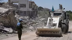 Seorang penjaga perdamaian PBB asal Spanyol mengarahkan buldoser yang membuka jalan di depan rumah-rumah yang hancur dalam bentrokan baru-baru ini antara pejuang Hizbullah dan pasukan Israel di desa Dibbine, Lebanon tenggara, Jumat (5/6/2026), sehari setelah pasukan Israel mundur. (Foto: AP/ Hussein Malla)