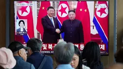 Orang-orang menyaksikan layar televisi yang menampilkan gambar arsip pemimpin Korea Utara (Korut) Kim Jong Un (kanan) dan Presiden China Xi Jinping di Stasiun Kereta Api Seoul di Seoul, Korea Selatan, Jumat (5/6/2026). (Foto: AP/ Ahn Young-joon)